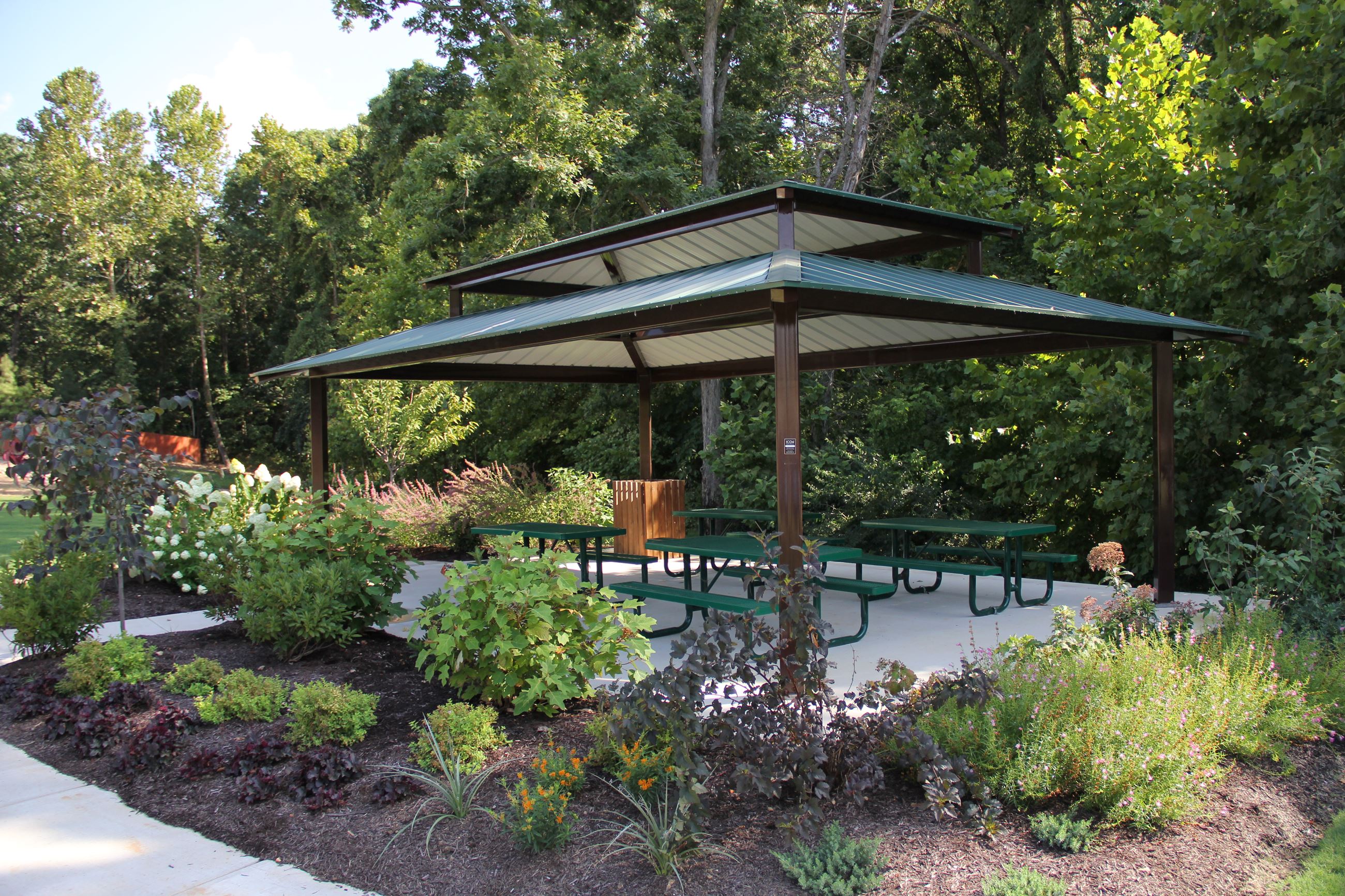 Enfield Park Image of Veranda and four picnic tables with shrubbery surrounding it